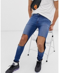 ASOS DESIGN Super Spray On Jeans In Mid Blue With Open Rips
