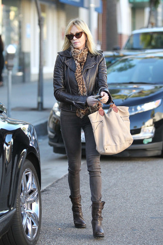 Melanie Griffith wearing Tan Canvas Tote Bag, Black Leather Ankle Boots, Grey Jeans, Black Leather Biker Jacket