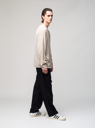 Beige Fleece Sweatshirt Outfits For Men: This relaxed pairing of a beige fleece sweatshirt and black chinos is a winning option when you need to look cool and casual in a flash. Introduce a pair of white and black leather low top sneakers to this outfit et voila, the look is complete.