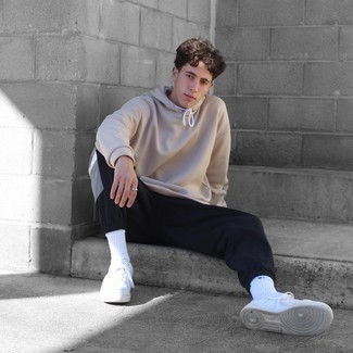 Beige Hoodie Outfits For Men: Such pieces as a beige hoodie and black chinos are the perfect way to inject extra cool into your current wardrobe. When not sure about what to wear when it comes to footwear, go with a pair of white leather low top sneakers.