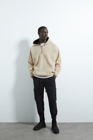 Black Canvas High Top Sneakers Outfits For Men: For an outfit that's very easy but can be modified in a variety of different ways, consider teaming a beige fleece hoodie with black cargo pants. Let your sartorial prowess truly shine by finishing off your getup with a pair of black canvas high top sneakers.
