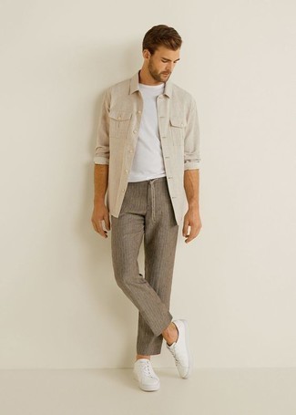 Brown Vertical Striped Chinos Outfits: Try teaming a beige long sleeve shirt with brown vertical striped chinos to effortlessly deal with whatever this day has in store for you. Let your sartorial expertise truly shine by finishing off this look with a pair of white canvas low top sneakers.