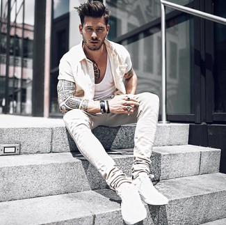 Khaki Jeans Outfits For Men: Wear a beige short sleeve shirt and khaki jeans for a casually cool and trendy ensemble. A pair of white low top sneakers is a savvy idea to round off this look.