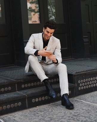 Black Dress Shirt Outfits For Men: Choose a black dress shirt and a beige suit to ooze class and refinement. When it comes to footwear, go for something on the laid-back end of the spectrum and finish this ensemble with black leather chelsea boots.