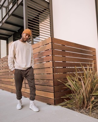 Tobacco Beanie Outfits For Men: A beige sweatshirt and a tobacco beanie are essential in any modern man's versatile casual sartorial arsenal. When it comes to footwear, this ensemble is rounded off brilliantly with grey athletic shoes.