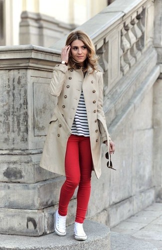 Beige Trenchcoat Outfits For Women: This relaxed pairing of a beige trenchcoat and red skinny jeans is a real life saver when you need to look stylish but have no time. Take an otherwise mostly dressed-up ensemble in a more informal direction with white canvas high top sneakers.