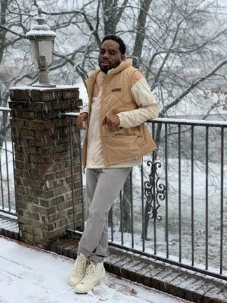 Tan Quilted Gilet Outfits For Men: Dial it down a notch in this functional combo of a tan quilted gilet and grey jeans. Here's how to tone it down: beige canvas high top sneakers.