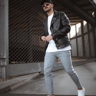Black Biker Jacket Outfits For Men: A black biker jacket and grey vertical striped chinos are among those super versatile menswear essentials that can reshape your wardrobe. Introduce a pair of white canvas low top sneakers to the equation and the whole getup will come together wonderfully.
