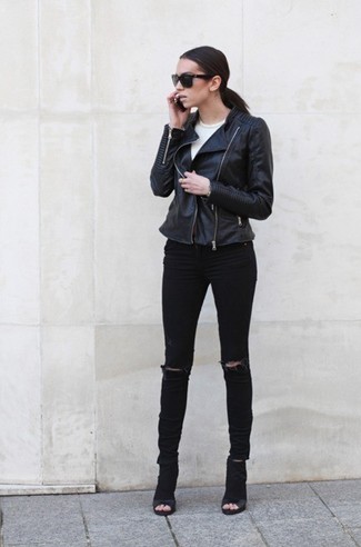 A black leather biker jacket and black ripped skinny jeans worn together are a total eye candy for girls who prefer relaxed styles. Get a bit experimental with footwear and spruce up this getup by rounding off with a pair of black cutout suede ankle boots.