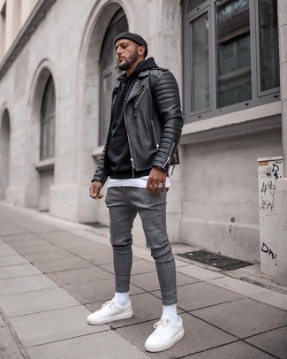 Black Quilted Leather Biker Jacket Outfits For Men: For an off-duty menswear style with a modern spin, marry a black quilted leather biker jacket with grey chinos. Introduce white leather low top sneakers to the equation to tie the whole thing together.