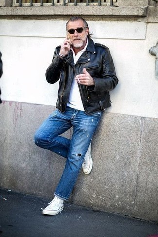 Navy Ripped Jeans Outfits For Men: This off-duty combination of a black leather biker jacket and navy ripped jeans is a fail-safe option when you need to look great but have no time. White canvas high top sneakers are a stylish companion for your look.