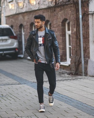 Black Print Canvas Low Top Sneakers Outfits For Men: Wear a black leather biker jacket and black skinny jeans to put together an interesting and city casual outfit. Rounding off with black print canvas low top sneakers is the most effective way to inject an element of refinement into this look.