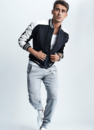 Black and White Varsity Jacket Outfits For Men: A black and white varsity jacket and grey sweatpants make for the perfect foundation for a casually stylish look. When not sure as to the footwear, go with a pair of white high top sneakers.