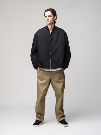 Black Canvas Low Top Sneakers Outfits For Men: A black bomber jacket and khaki chinos are both versatile menswear must-haves that will integrate well within your off-duty collection. Make this ensemble more functional by rounding off with a pair of black canvas low top sneakers.