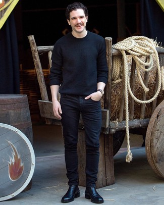 Kit Harington wearing Navy Horizontal Striped Canvas Watch, Black Leather Chelsea Boots, Black Jeans, Black Crew-neck Sweater