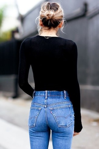 A black crew-neck sweater and blue skinny jeans are a cool go-to pairing to have in your sartorial collection.