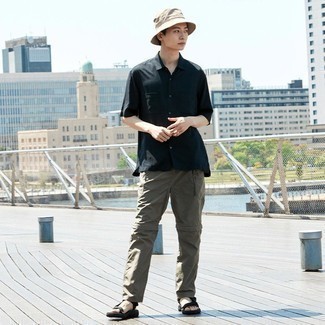 Beige Bucket Hat Outfits For Men: Team a black short sleeve shirt with a beige bucket hat for a laid-back ensemble with a modern spin. Complement your getup with a pair of black canvas sandals to make a classic getup feel suddenly edgier.