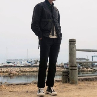 Black and White Varsity Jacket Outfits For Men: Effortlessly blurring the line between sharp and off-duty, this combo of a black and white varsity jacket and black chinos can easily become your favorite. A pair of black and white canvas high top sneakers can effortlessly dial down a classic getup.