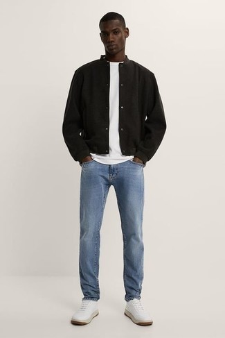 Black Varsity Jacket Outfits For Men: To create a casual ensemble with a modern finish, pair a black varsity jacket with light blue jeans. Introduce a pair of white leather low top sneakers to the equation and the whole ensemble will come together perfectly.