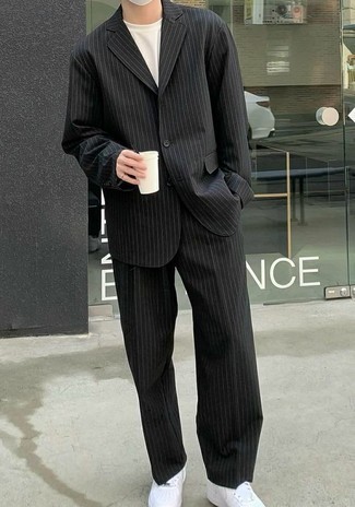Black Vertical Striped Suit Outfits: Consider wearing a black vertical striped suit and a white crew-neck t-shirt to feel confident and look smart. Get a little creative with shoes and tone down this outfit by wearing a pair of white leather low top sneakers.