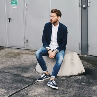 Blue Denim Blazer Outfits For Men: This off-duty combination of a blue denim blazer and blue ripped skinny jeans is a life saver when you need to look dapper but have no extra time. Go off the beaten track and shake up your look by finishing off with a pair of navy and white canvas low top sneakers.