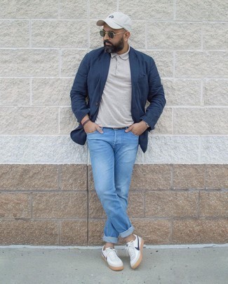 White and Navy Low Top Sneakers Outfits For Men: Such items as a navy cotton blazer and light blue jeans are the perfect way to introduce extra elegance into your daily arsenal. White and navy low top sneakers will give a laid-back feel to your outfit.
