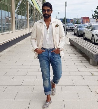 White Blazer Outfits For Men: A white blazer and blue jeans married together are a wonderful match. A pair of navy and white horizontal striped canvas espadrilles easily steps up the cool of this getup.