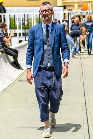 Grey Waistcoat Outfits: This refined pairing of a grey waistcoat and navy chinos is a common choice among the dapper guys. Put a more casual spin on your getup by slipping into a pair of white leather low top sneakers.