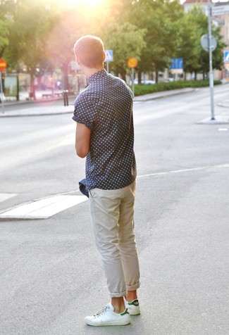 A blue denim jacket and beige chinos are a combo that every modern gentleman should have in his casual routine. Throw white and green leather low top sneakers into the mix to keep the ensemble fresh.