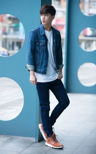 Handsome fashionable man in a denim jacket with a white Tshirt and torn  jeans near the fence Stock Photo  Alamy
