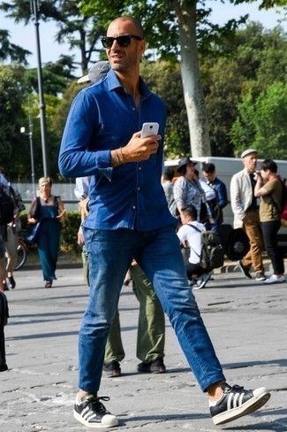 Men's Blue Chambray Long Sleeve Shirt, Blue Jeans, Black and White Leather Low Top Sneakers, Black Sunglasses