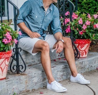 Men's Blue Chambray Long Sleeve Shirt, White Denim Shorts, White Canvas Low Top Sneakers, Grey Leather Watch