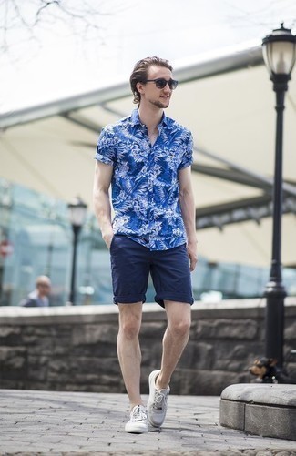 Charcoal Canvas Low Top Sneakers Outfits For Men: A blue floral short sleeve shirt and navy shorts worn together are a perfect match. Let your outfit coordination prowess truly shine by finishing this getup with charcoal canvas low top sneakers.