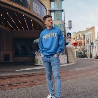 Blue Print Sweatshirt Outfits For Men: This combination of a blue print sweatshirt and light blue skinny jeans will be undeniable proof of your skills in men's fashion even on lazy days. White and black leather low top sneakers will bring a dose of refinement to an otherwise mostly casual outfit.