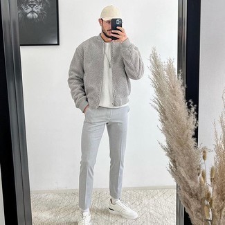 White and Navy Leather Low Top Sneakers Outfits For Men: Make a grey fleece bomber jacket and grey chinos your outfit choice to achieve an extra stylish and modern-looking casual outfit. Shake up your getup by rounding off with a pair of white and navy leather low top sneakers.