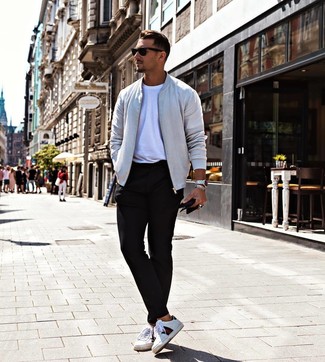 Grey Bomber Jacket Outfits For Men: Go for a grey bomber jacket and black chinos for a casual kind of elegance. Finishing with a pair of white print leather low top sneakers is a guaranteed way to infuse a laid-back vibe into this ensemble.