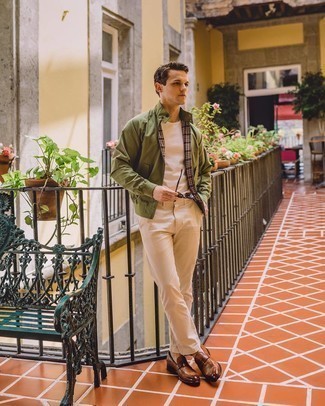 Olive Bomber Jacket Outfits For Men: If you prefer casual style, why not wear this combo of an olive bomber jacket and beige chinos? Complement this getup with brown leather loafers to effortlessly step up the wow factor of any outfit.