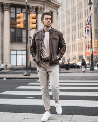 Dark Brown Leather Bomber Jacket Outfits For Men: This off-duty combination of a dark brown leather bomber jacket and grey chinos is very easy to put together in no time, helping you look amazing and ready for anything without spending too much time rummaging through your wardrobe. A pair of white canvas low top sneakers instantly dials up the street cred of your look.