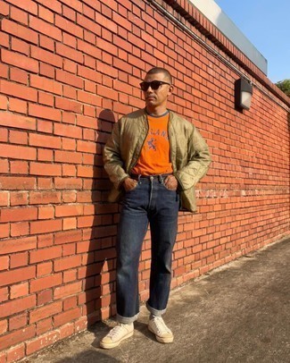 Orange Print Crew-neck T-shirt Outfits For Men: An orange print crew-neck t-shirt and navy jeans married together are a match made in heaven for gents who love casually stylish styles. Introduce a pair of white canvas low top sneakers to the equation and off you go looking spectacular.