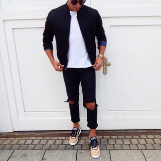 Tan Low Top Sneakers Outfits For Men: Wear a black bomber jacket with black ripped jeans for a bold casual and trendy getup. If you wish to immediately kick up this look with a pair of shoes, why not complete this outfit with a pair of tan low top sneakers?