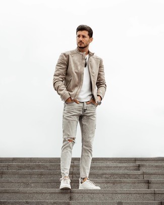 Beige Suede Bomber Jacket Outfits For Men: This combo of a beige suede bomber jacket and grey ripped jeans has a very casual and approachable kind of vibe. Go ahead and add white canvas low top sneakers to the mix for a touch of refinement.