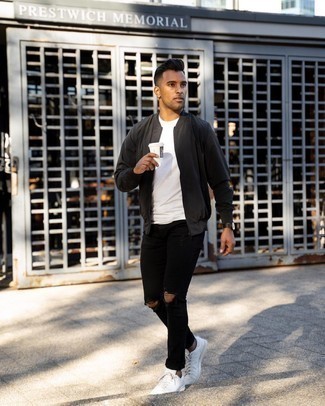 Black Bomber Jacket Outfits For Men: A black bomber jacket and black ripped jeans worn together are a sartorial dream for guys who love off-duty getups. To bring out a classy side of you, complement this ensemble with a pair of white leather low top sneakers.