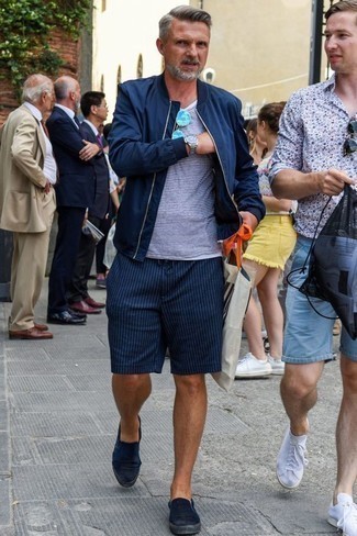 Navy Vertical Striped Shorts Outfits For Men: For a look that provides functionality and dapperness, try teaming a navy bomber jacket with navy vertical striped shorts. Navy canvas slip-on sneakers pull the getup together.