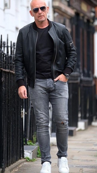 Charcoal Ripped Skinny Jeans Outfits For Men: A black leather bomber jacket and charcoal ripped skinny jeans are a favorite off-duty combination for many style-savvy men. Feeling bold today? Dress up your outfit by rocking a pair of white leather low top sneakers.