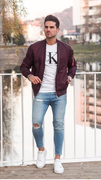 Burgundy Bomber Jacket Outfits For Men: This laid-back pairing of a burgundy bomber jacket and light blue ripped skinny jeans is a surefire option when you need to look stylish but have zero time. Finishing with a pair of white canvas low top sneakers is a guaranteed way to breathe a touch of refinement into your look.