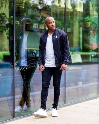 Navy Skinny Jeans Casual Outfits For Men: This combination of a navy bomber jacket and navy skinny jeans makes for the perfect base for a multitude of ensembles. Complete your getup with a pair of white leather low top sneakers and you're all done and looking killer.