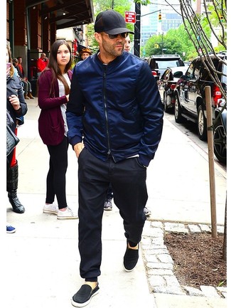 Black Canvas Slip-on Sneakers Outfits For Men After 40: If you enjoy a more casual approach to styling, why not go for a navy bomber jacket and black sweatpants? Go ahead and add black canvas slip-on sneakers to the mix for a sense of sophistication. If you often wonder how to dress your age, this pairing is a practical example.