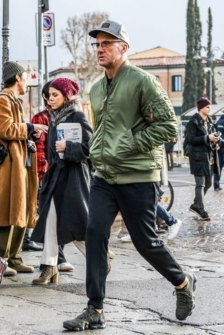 Dark Green Athletic Shoes Outfits For Men: This ensemble with an olive nylon bomber jacket and navy sweatpants isn't super hard to put together and is easy to adapt. Let your styling prowess truly shine by finishing off your look with a pair of dark green athletic shoes.