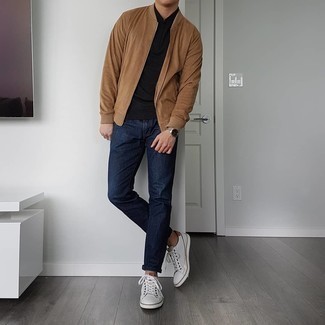 Tan Bomber Jacket Outfits For Men: This relaxed combo of a tan bomber jacket and navy jeans is a foolproof option when you need to look laid-back and cool in a flash. Now all you need is a pair of white leather low top sneakers.
