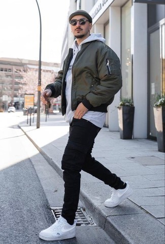 Black Cargo Pants Outfits: For a relaxed casual menswear style with a modern take, you can opt for an olive nylon bomber jacket and black cargo pants. Consider a pair of white leather low top sneakers as the glue that brings your getup together.